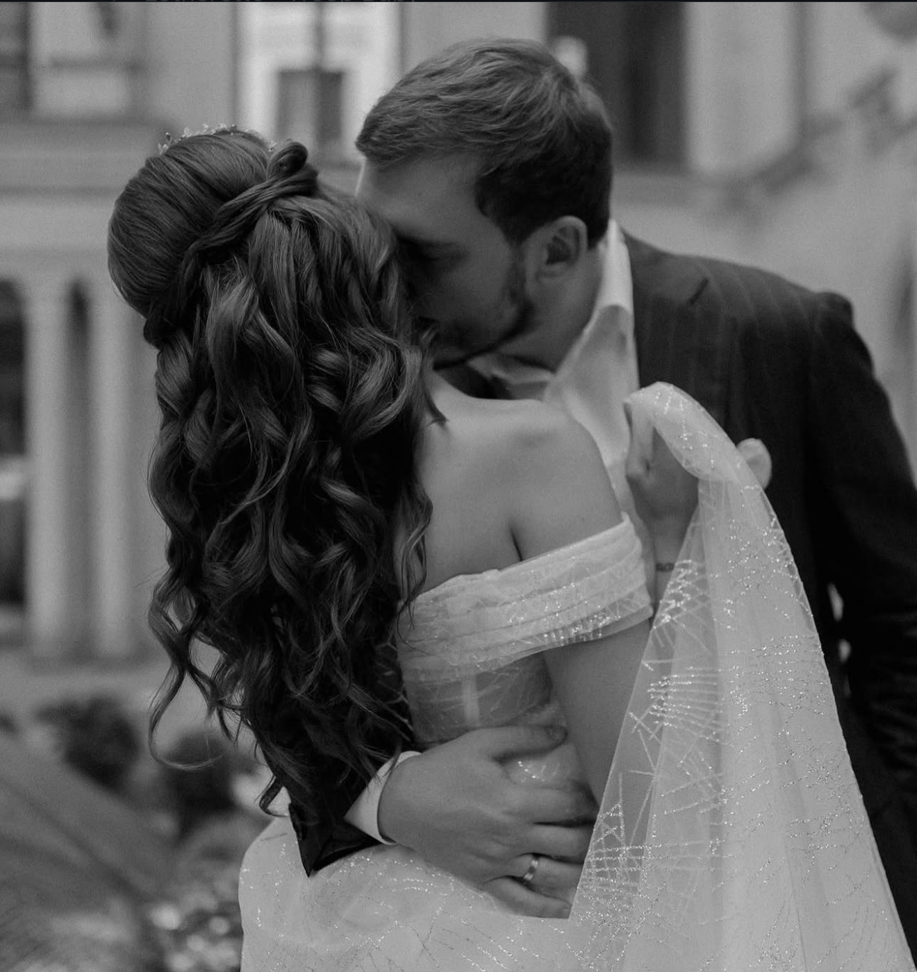 Bride with half-up hairstyle kissing groom