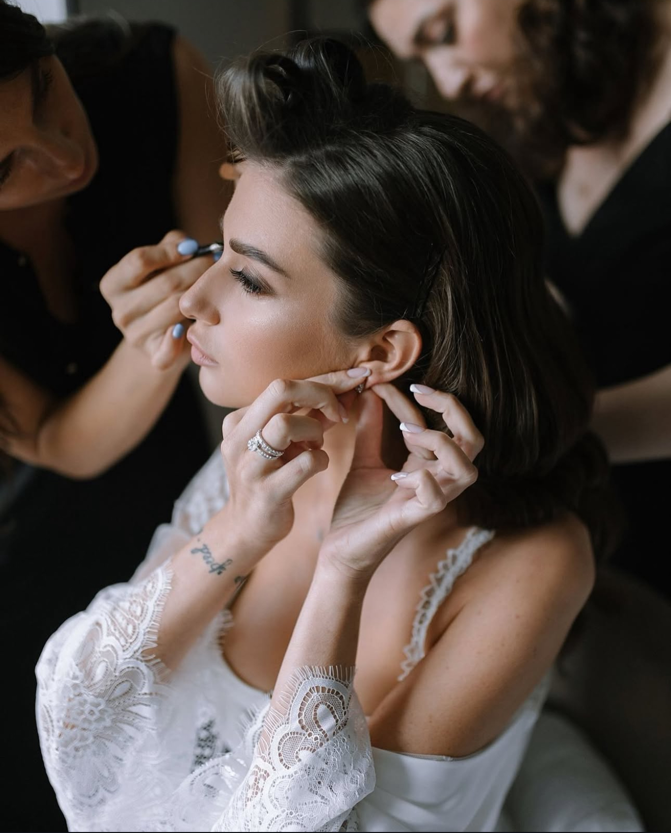 Bride putting on earrings